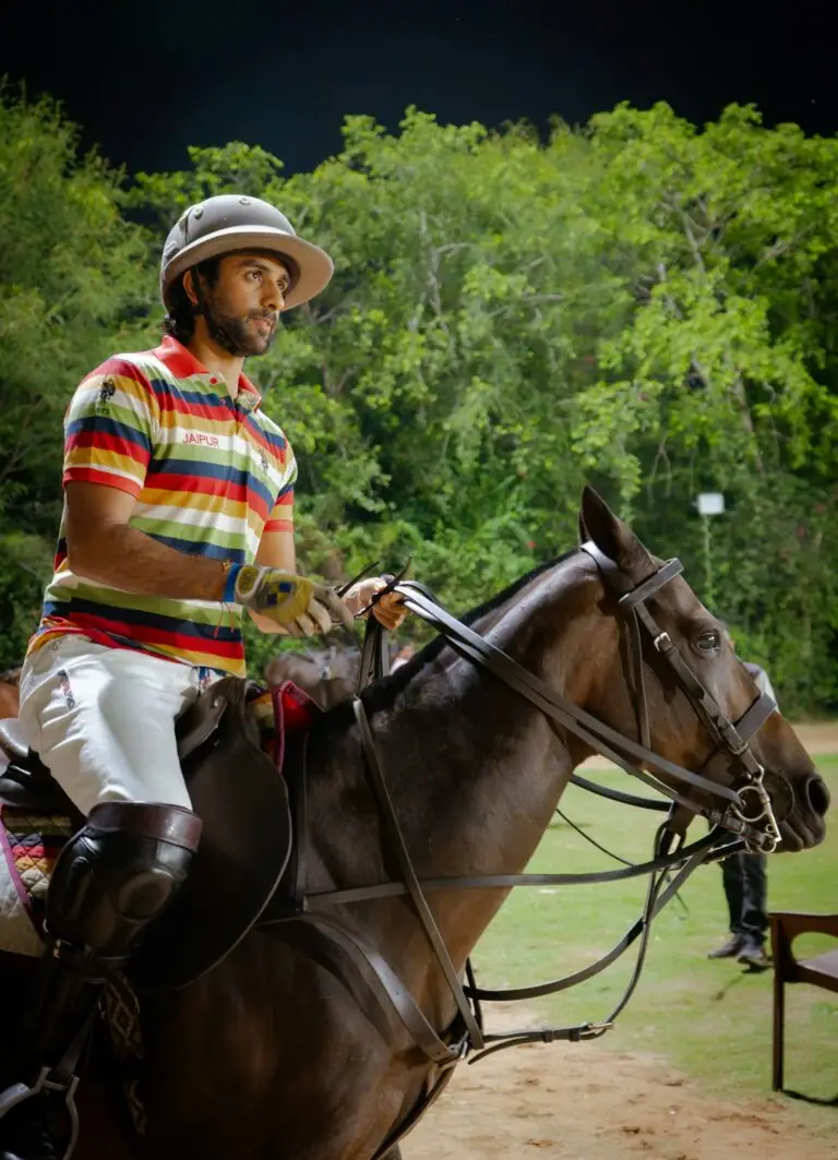 A polo player in a striped shirt riding in Jaipur