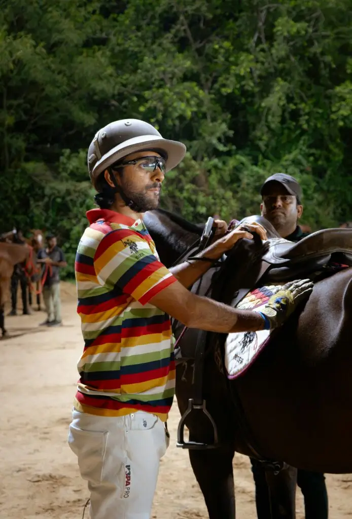 A polo player adjusting a saddle