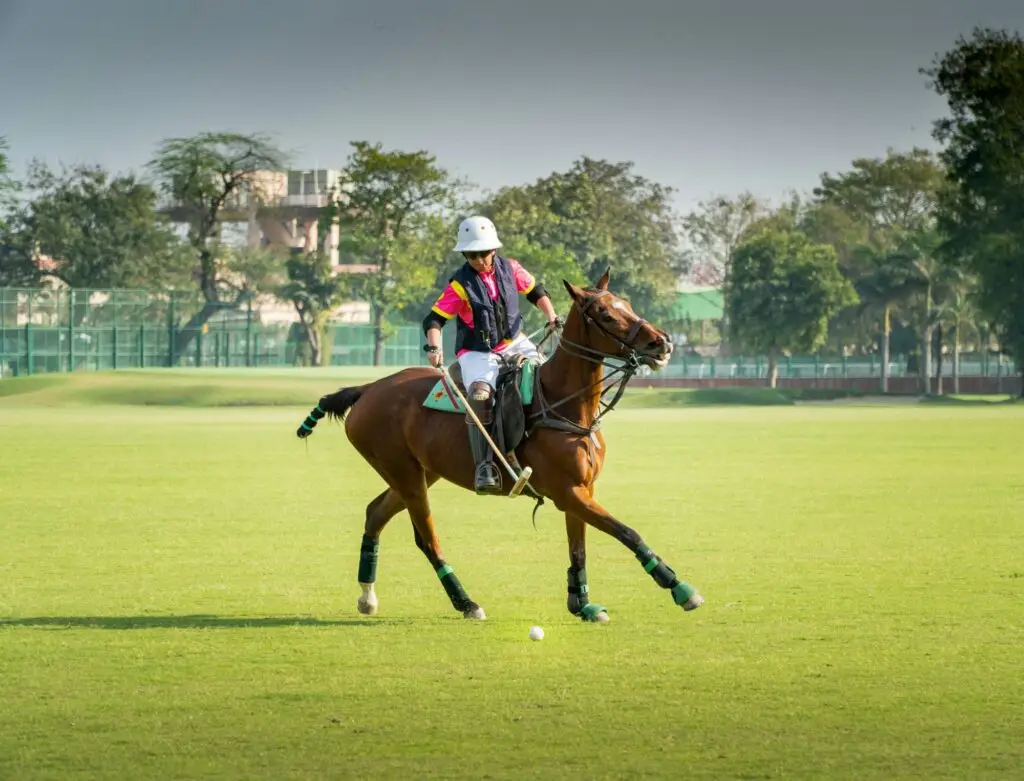 A polo player swinging at the ball