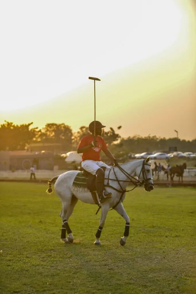 A polo player riding a white horse