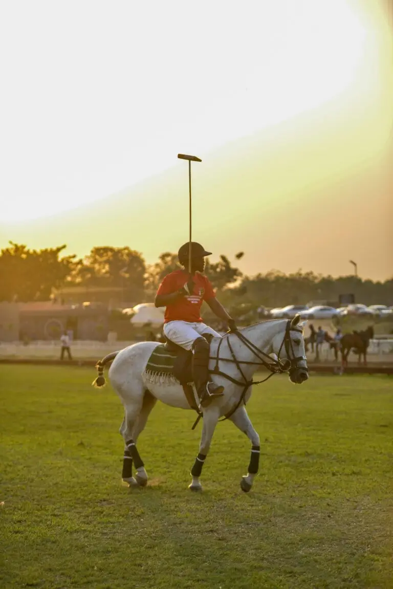 A polo player riding a white horse